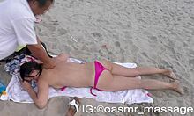 Nuori tyttöystävä antaa yläosattomissa hieronta rannalla