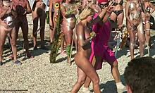 Nudisti sluts suorittaa heidän rituaalinen tanssia rannalla
