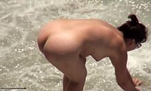 Тъмнокос аматьор в сенките е гол на плажа