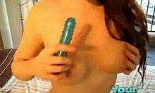 Wanita berambut coklat berisi memasukkan dildo biru ke dalam vaginanya