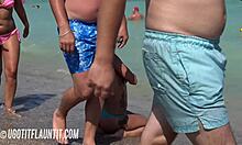 Bystig brunett med en fantastisk kropp visar upp sin solbränna på en strand