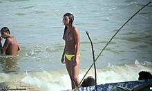 Una bomba sexy che mostra le sue tette sode su una spiaggia nudista