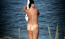 Nudis dengan payudara alami memamerkan tubuhnya di pantai nudis yang sepi
