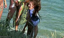 Tribal bodypaint hotties poserer med sværd og lort på en strand