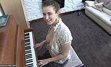 Playful-looking brunette with perky tits playing the piano topless