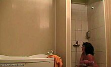 Ohromující žena relaxuje pod sprchou a je sledována