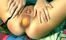 이상한 창녀가 거대한 오렌지 공을 그녀의 항문에 삽입합니다