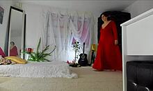 Sinnliches reifes Sonias-Heimvideo zeigt ihre neckischen Positionen in einem langen roten Kleid und enthüllt ihren haarigen Hintern, ihre Beine, Füße und Hüften mit natürlichen Brüsten