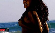 Egy fülledt fekete nő élvezi, hogy levetkőzik az óceánban