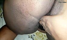 Uma mulher de ébano com uma vagina rosa é duplamente penetrada no ânus