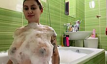 Uma adolescente grávida com seios grandes e bunda sexy toma um banho